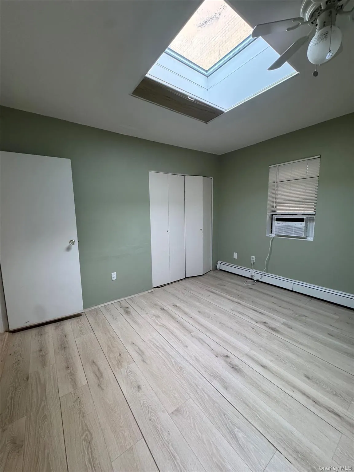 Bedroom with skylight, double closet, ceiling fan, new floors, and freshly painted. Bedroom with skylight, double closet, ceiling fan, new floors, and freshly painted.