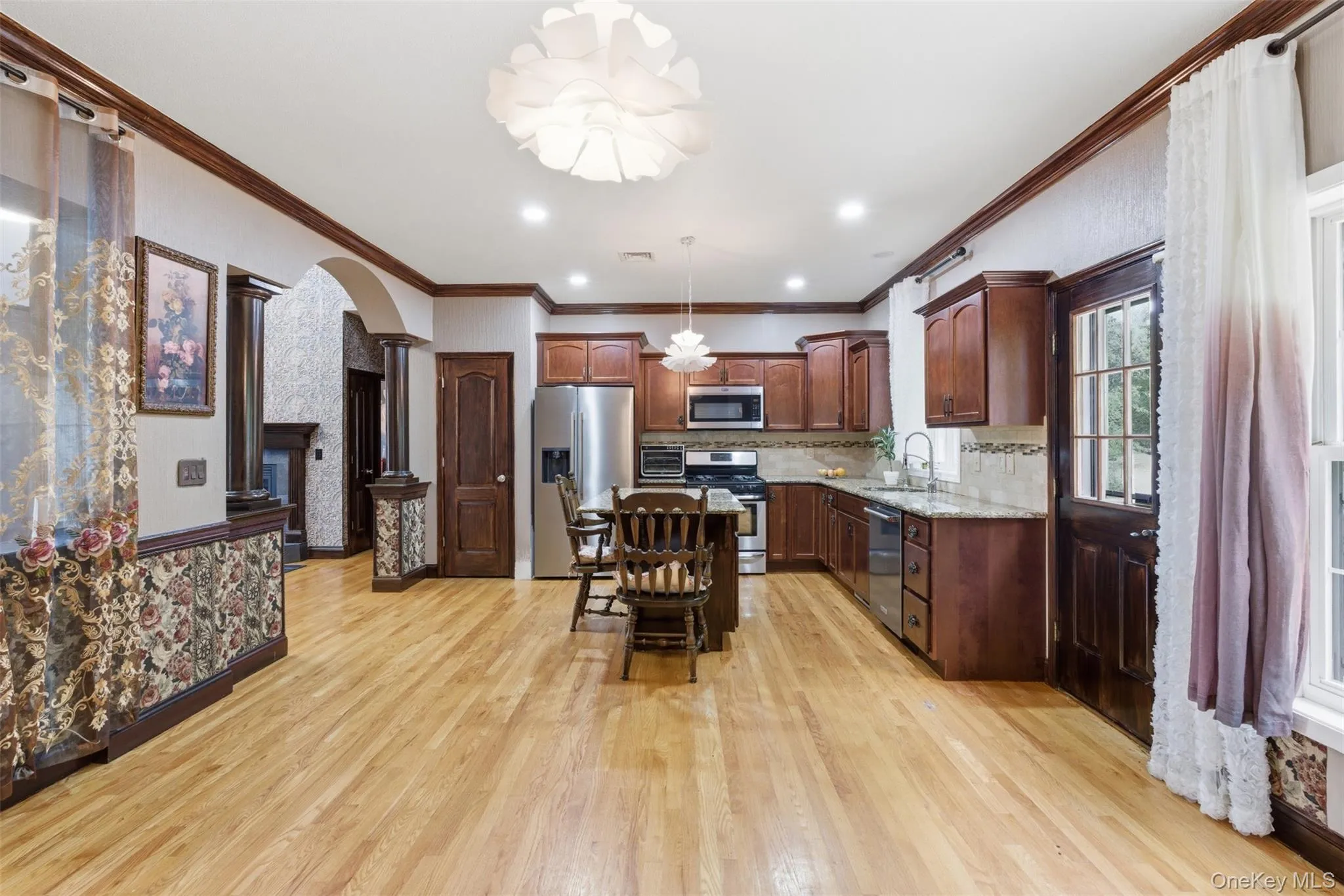 Kitchen featuring wood-finish flooring, recessed lighting, and a central island Kitchen featuring wood-finish flooring, recessed lighting, and a central island