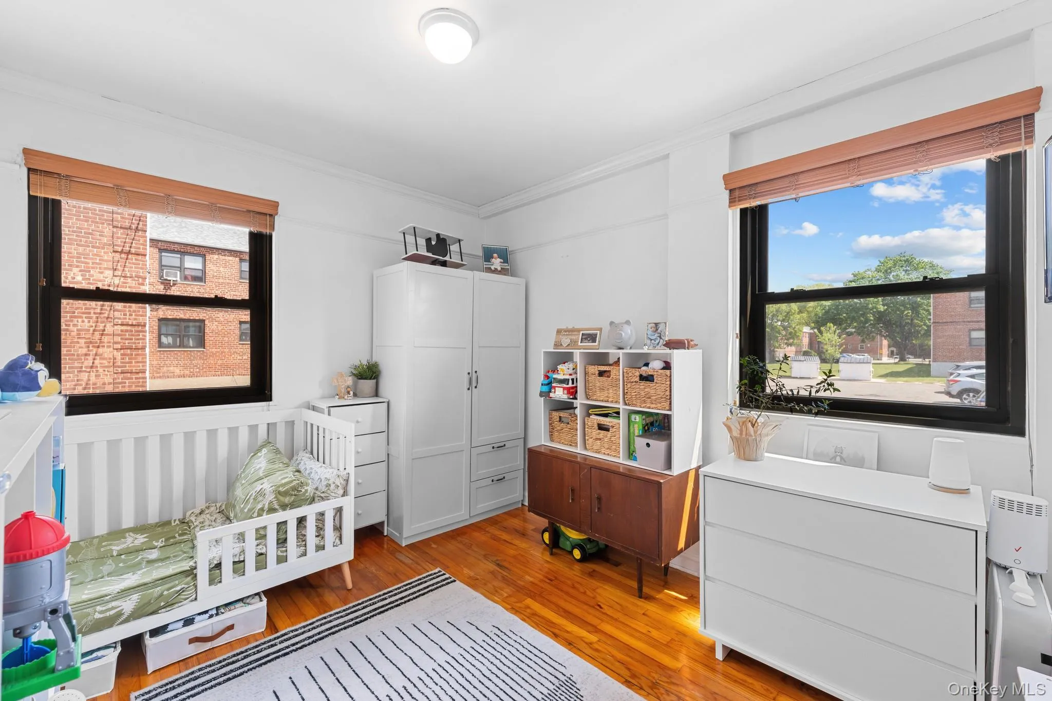 Bedroom with wood-finish flooring, two large windows. Bedroom with wood-finish flooring, two large windows.