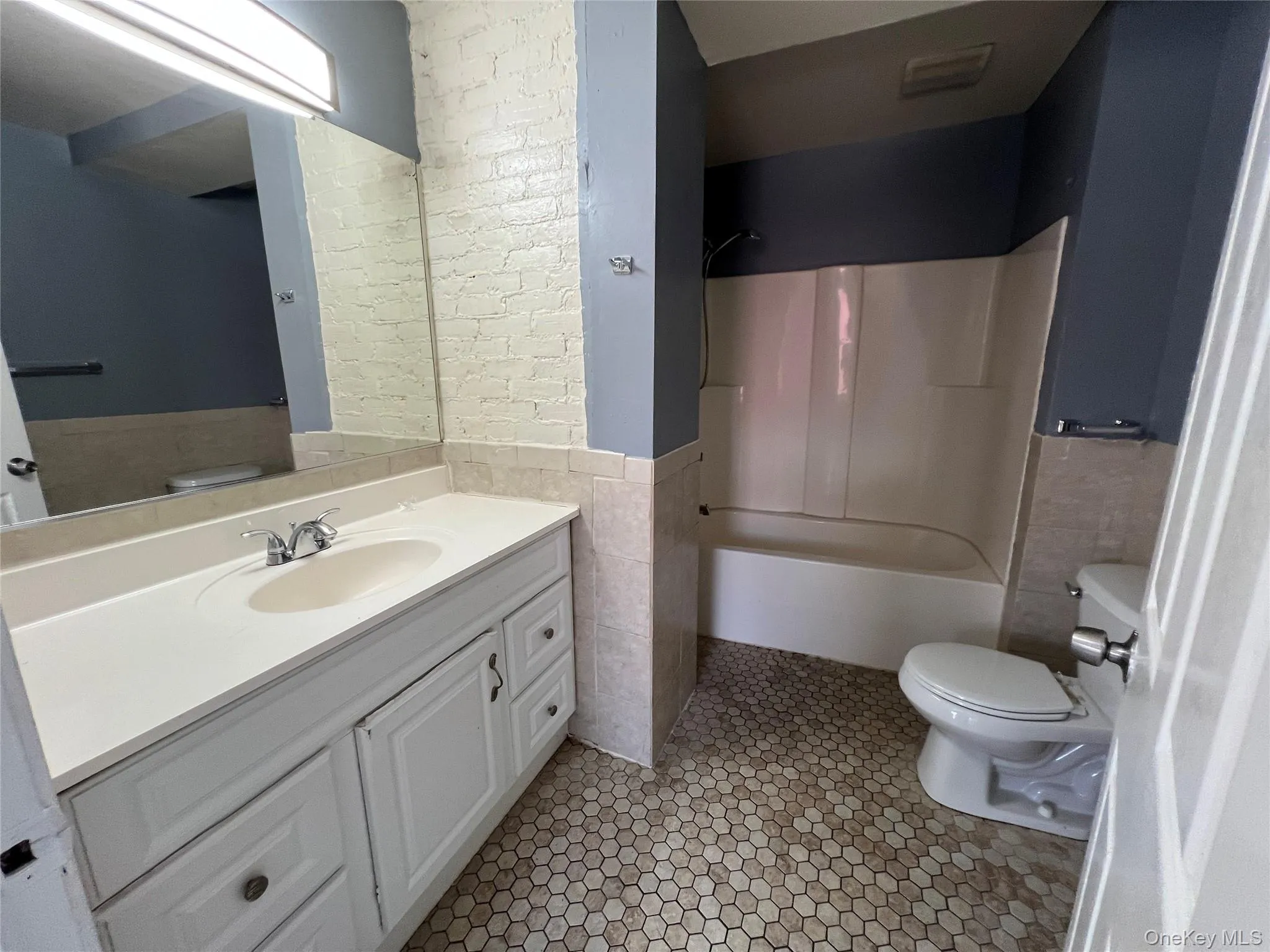 Bathroom featuring a single vanity with storage, a top-mounted sink, and a chrome faucet Bathroom featuring a single vanity with storage, a top-mounted sink, and a chrome faucet