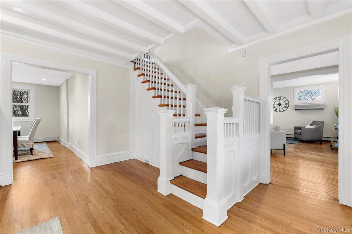 Stairway featuring hardwood / wood-style floors and beam ceiling Stairway featuring hardwood / wood-style floors and beam ceiling