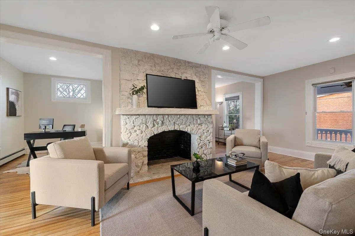 Living area with wood finished floors, a stone fireplace, recessed lighting, and a ceiling fan Living area with wood finished floors, a stone fireplace, recessed lighting, and a ceiling fan