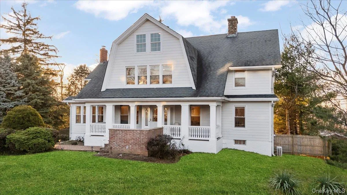 Rear view of property featuring a chimney, a porch, and a shingled roof Rear view of property featuring a chimney, a porch, and a shingled roof