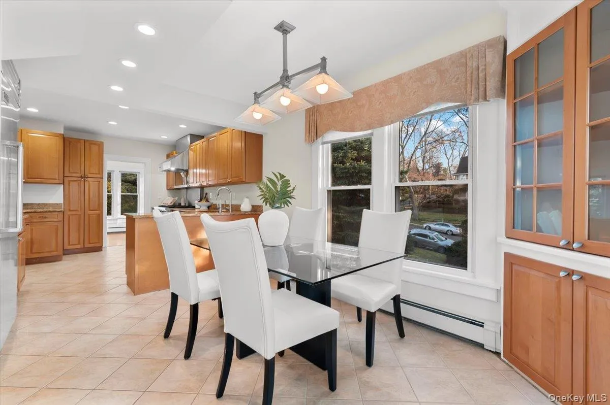 Dining area with recessed lighting, light tile patterned floors, and a baseboard radiator Dining area with recessed lighting, light tile patterned floors, and a baseboard radiator