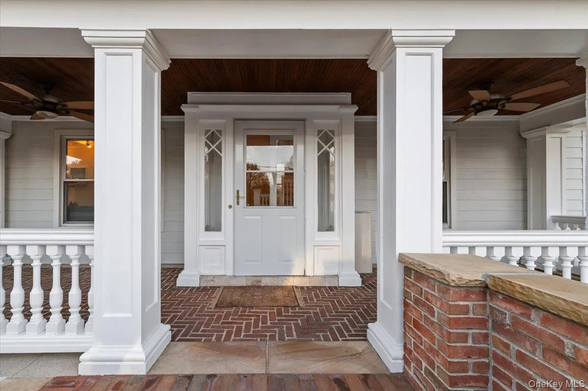 View of exterior entry with ceiling fan and a porch View of exterior entry with ceiling fan and a porch