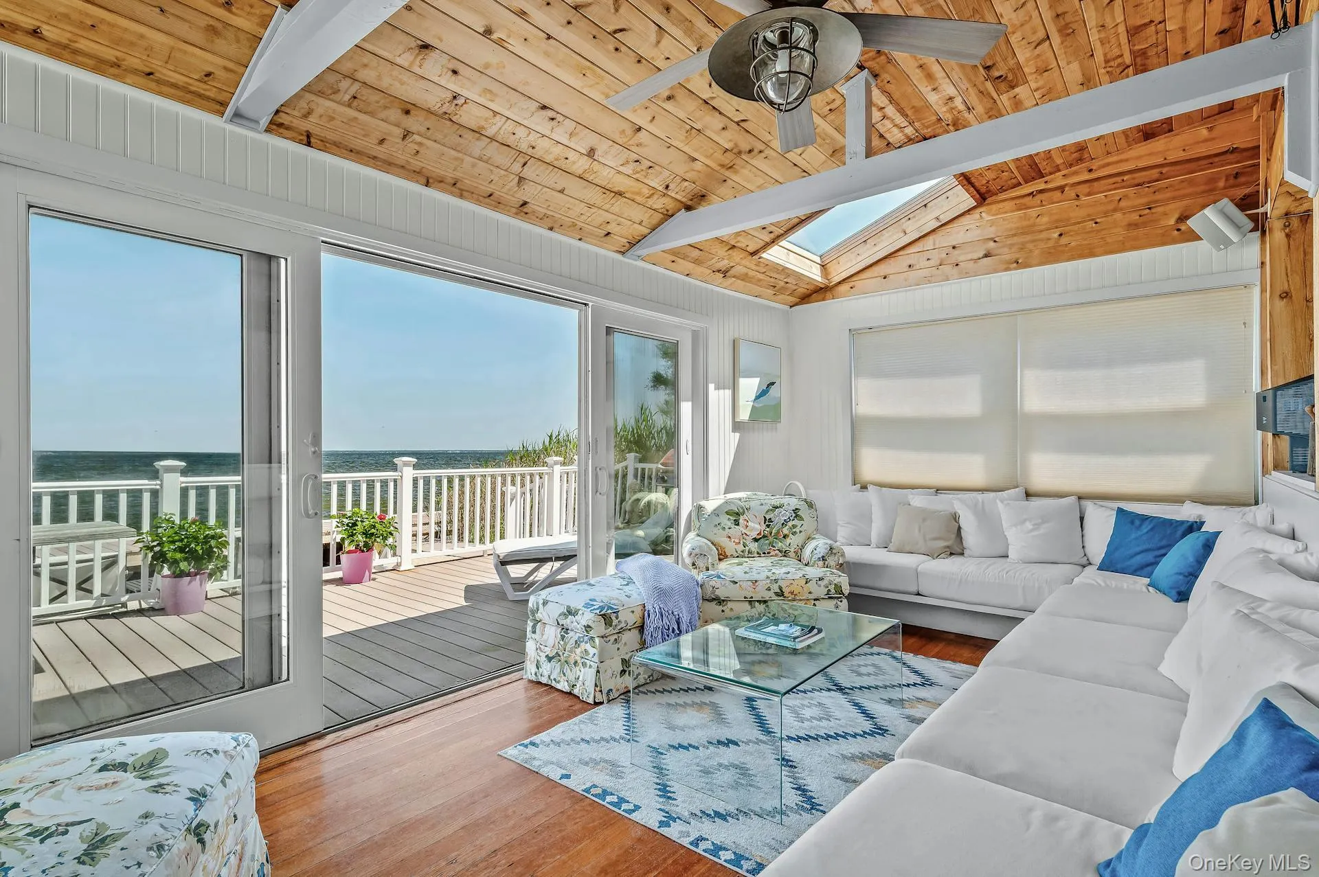 Interior living space with vaulted wood-plank ceiling, skylights, and ceiling fan Interior living space with vaulted wood-plank ceiling, skylights, and ceiling fan