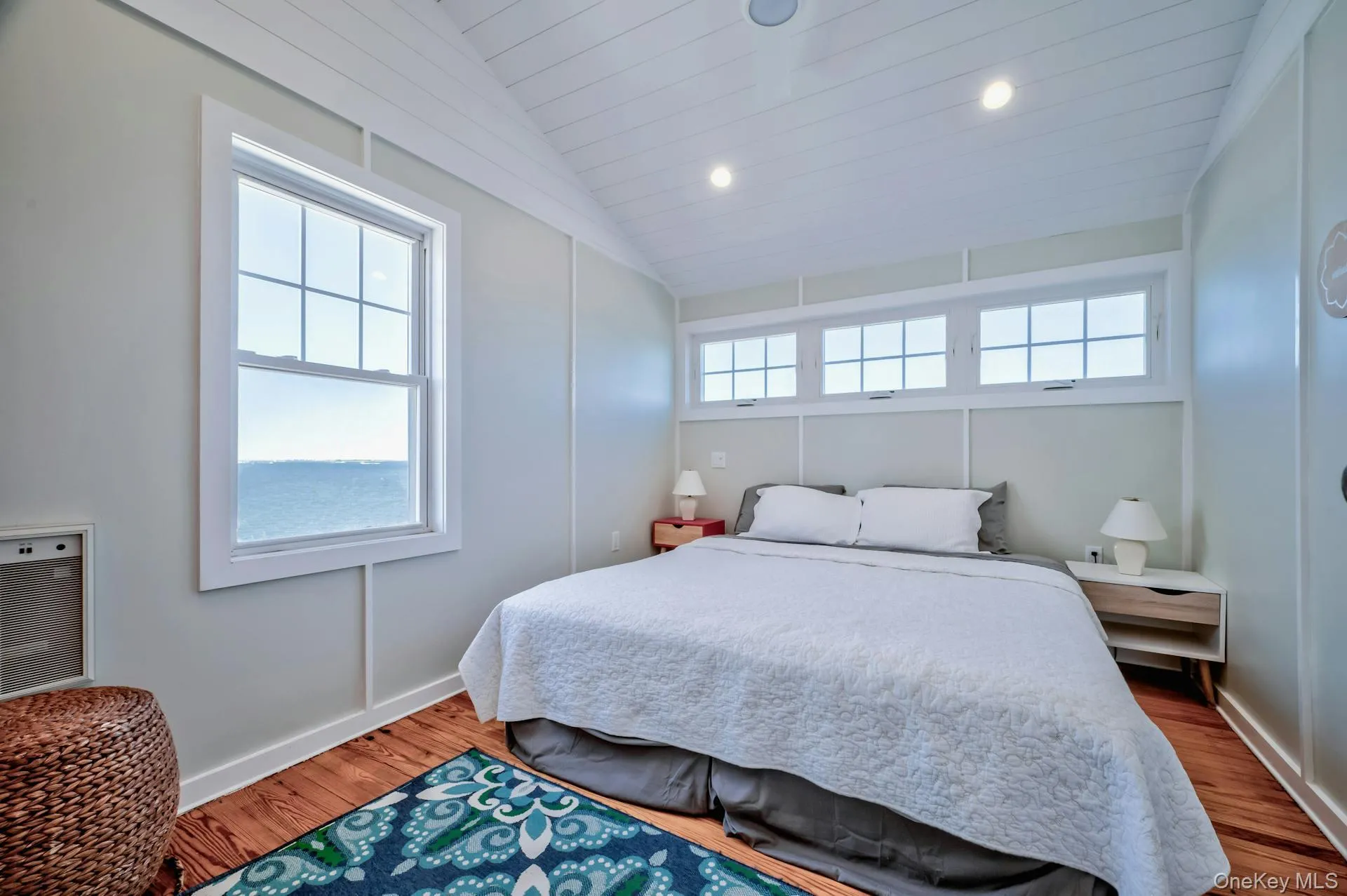 Waterfront window providing natural light, vaulted ceiling with recessed lighting, shiplap ceiling finish, and hardwood flooring Waterfront window providing natural light, vaulted ceiling with recessed lighting, shiplap ceiling finish, and hardwood flooring