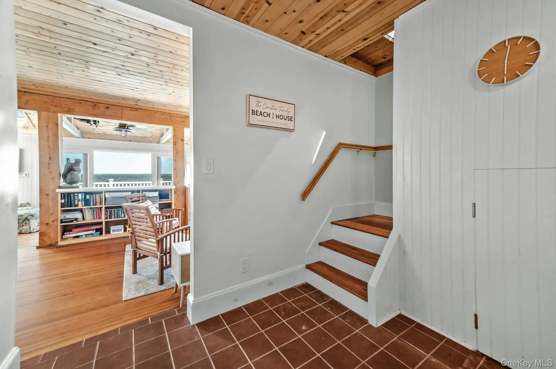 Interior staircase featuring wood treads and handrail, with terracotta tile flooring Interior staircase featuring wood treads and handrail, with terracotta tile flooring