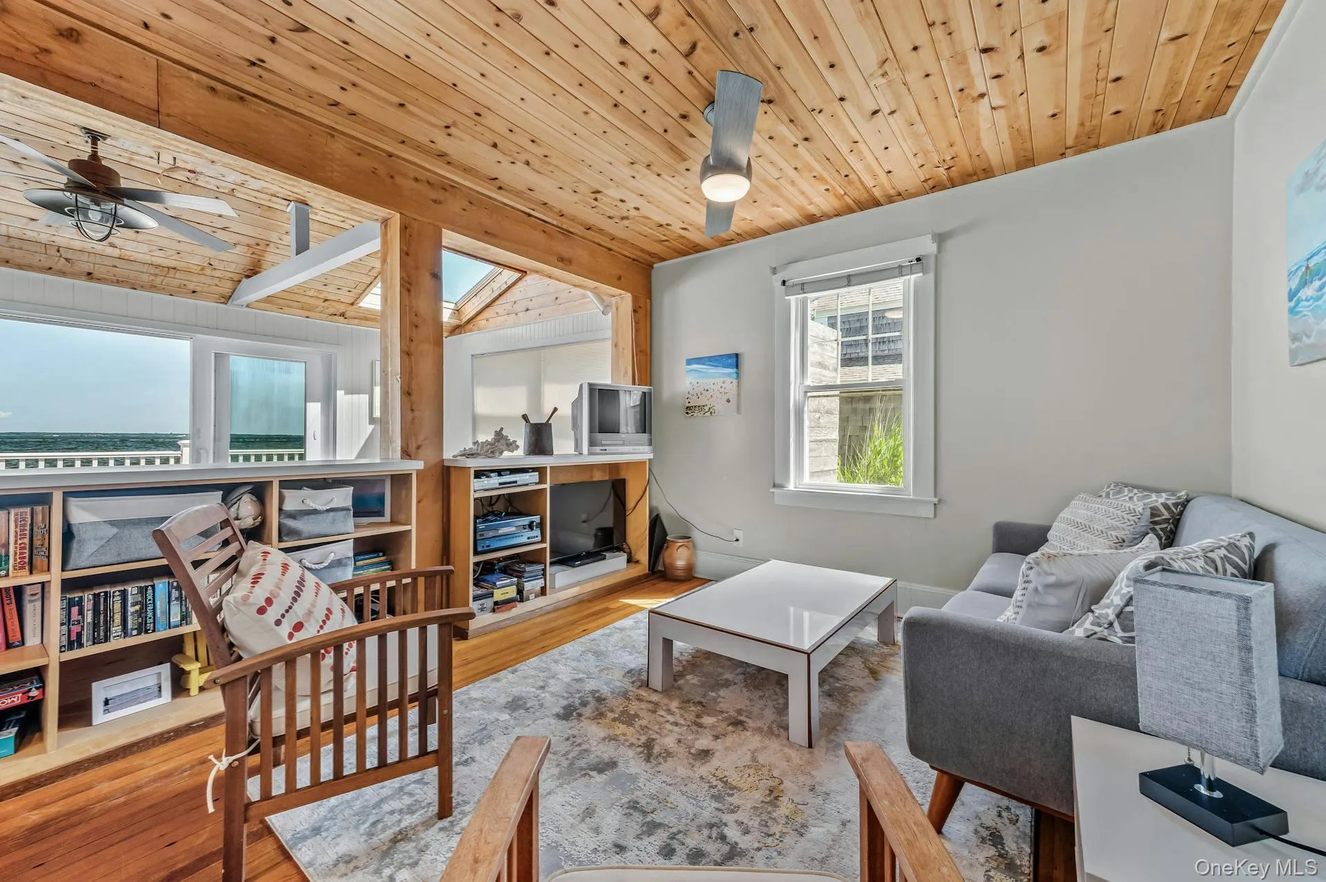 Living area featuring a natural wood plank ceiling, exposed wood beams, and warm wood-finish flooring Living area featuring a natural wood plank ceiling, exposed wood beams, and warm wood-finish flooring