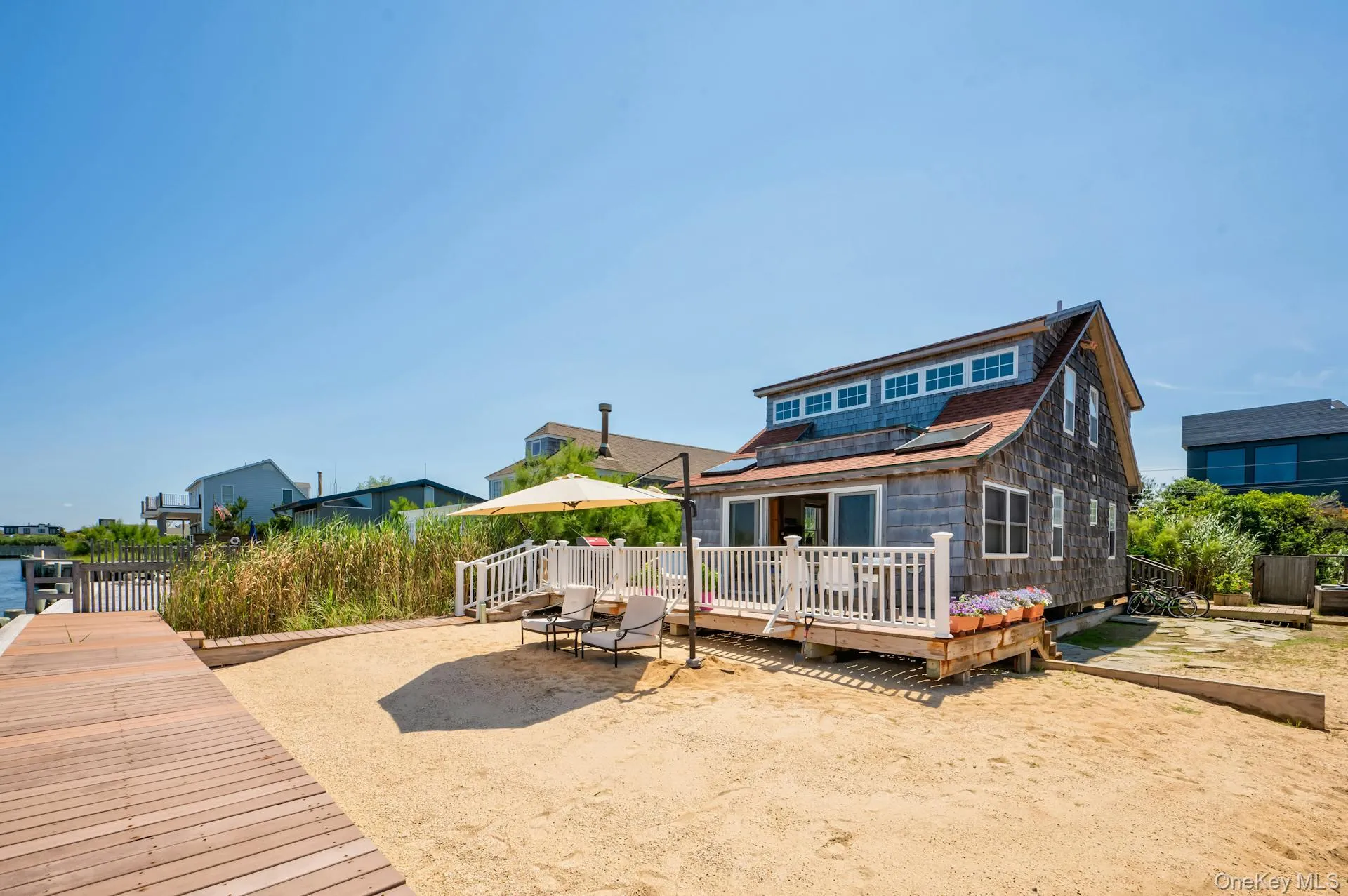 Shingle-sided residence featuring a multi-pane dormer window and solar panels Shingle-sided residence featuring a multi-pane dormer window and solar panels
