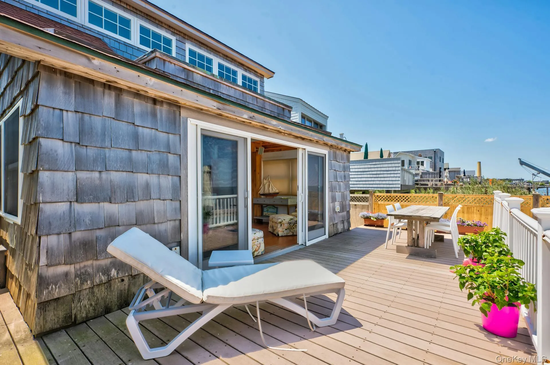 Spacious outdoor deck featuring composite flooring and a wooden privacy fence Spacious outdoor deck featuring composite flooring and a wooden privacy fence
