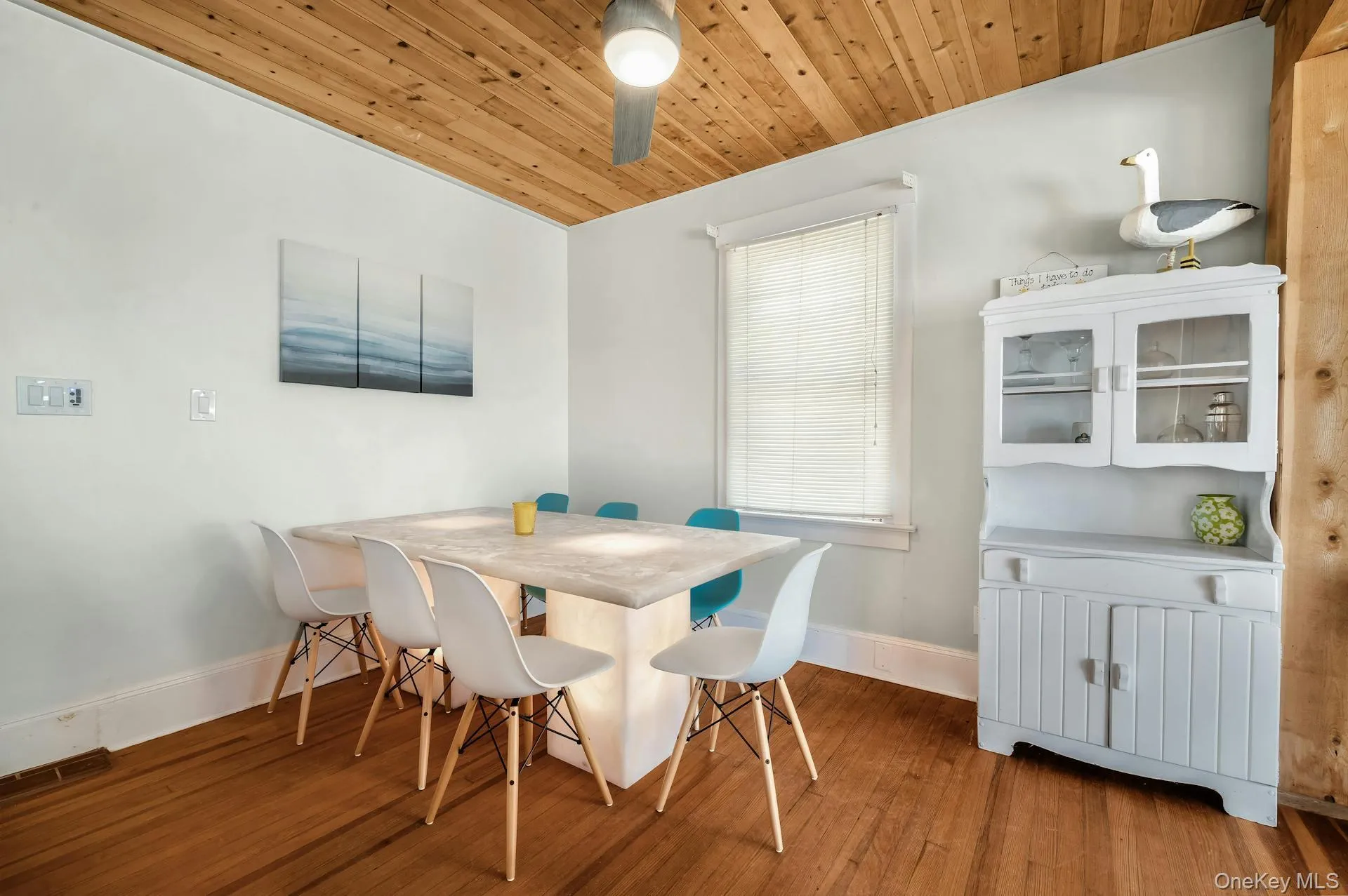 Dining area featuring wood-finish flooring and a distinctive wood-paneled ceiling Dining area featuring wood-finish flooring and a distinctive wood-paneled ceiling
