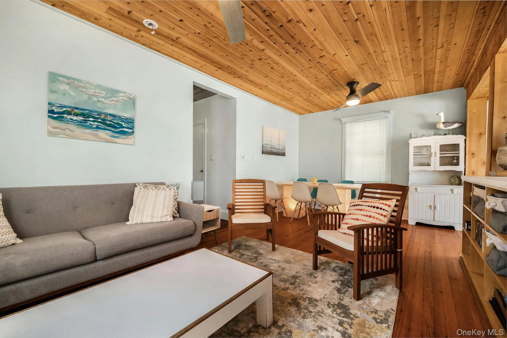 Vaulted wood-paneled ceiling with ceiling fan, light blue walls, and wood-finish flooring throughout Vaulted wood-paneled ceiling with ceiling fan, light blue walls, and wood-finish flooring throughout