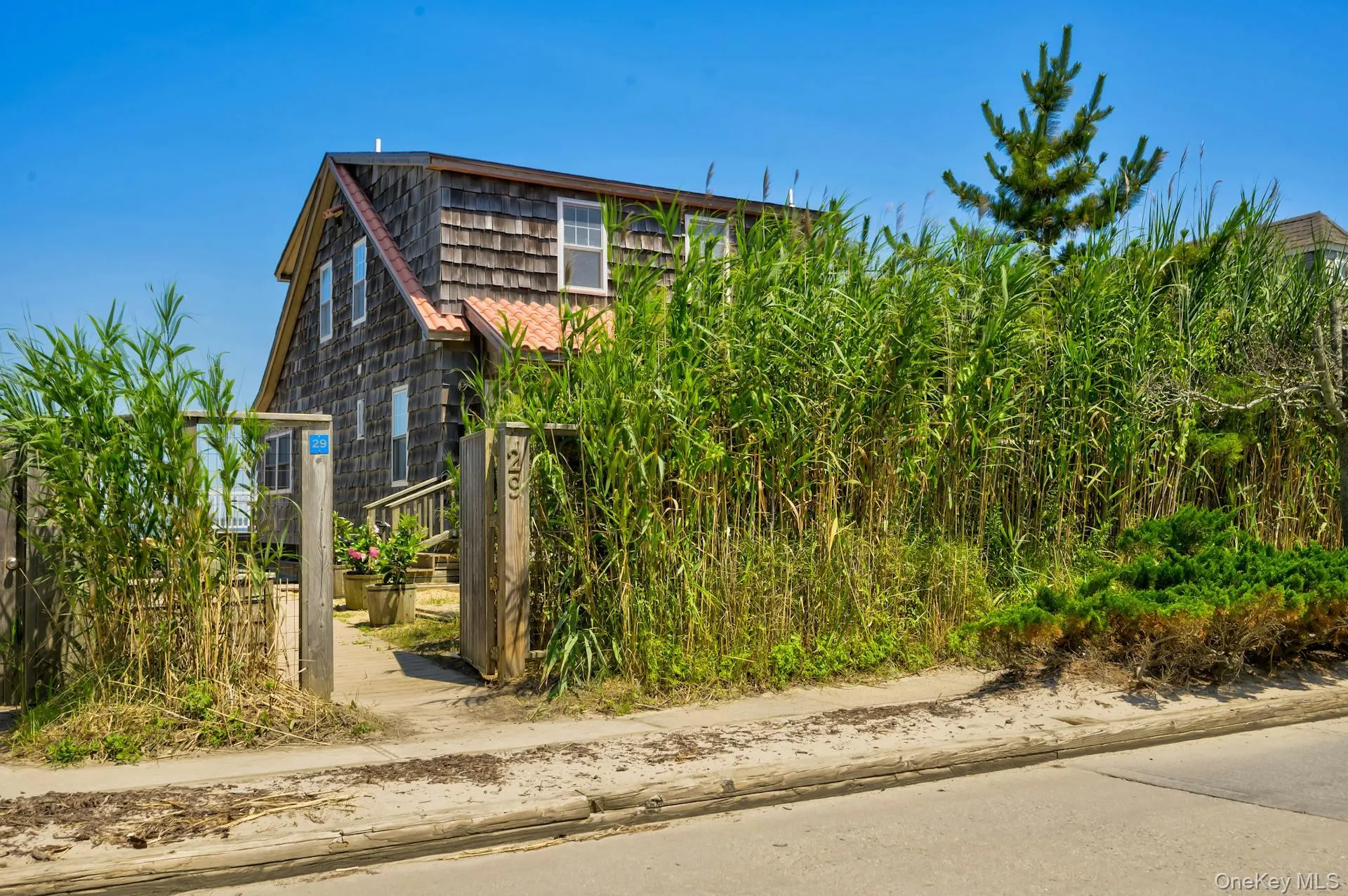 Wood shingle exterior featuring multiple windows and a gabled roofline with a terra cotta colored roof Wood shingle exterior featuring multiple windows and a gabled roofline with a terra cotta colored roof