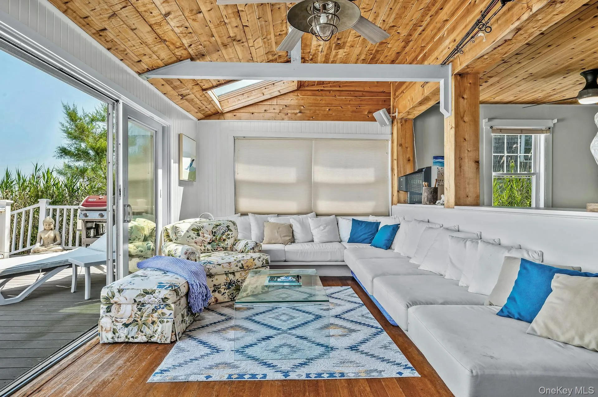 Living area featuring wood-finish flooring and a wood-paneled ceiling with exposed beams Living area featuring wood-finish flooring and a wood-paneled ceiling with exposed beams