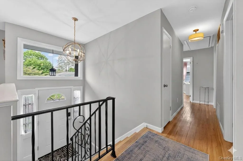 Entryway with a contemporary spherical chandelier, overhead transom window, and a white paneled door with decorative glass inserts Entryway with a contemporary spherical chandelier, overhead transom window, and a white paneled door with decorative glass inserts