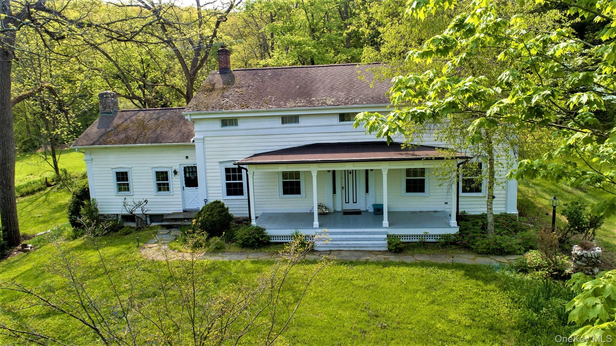 Rear view of property with covered porch, a yard, and a chimney Rear view of property with covered porch, a yard, and a chimney