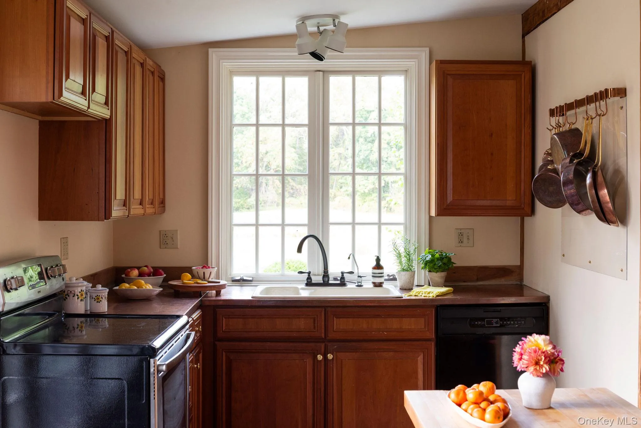 Kitchen featuring electric range, brown cabinets, and dishwasher Kitchen featuring electric range, brown cabinets, and dishwasher