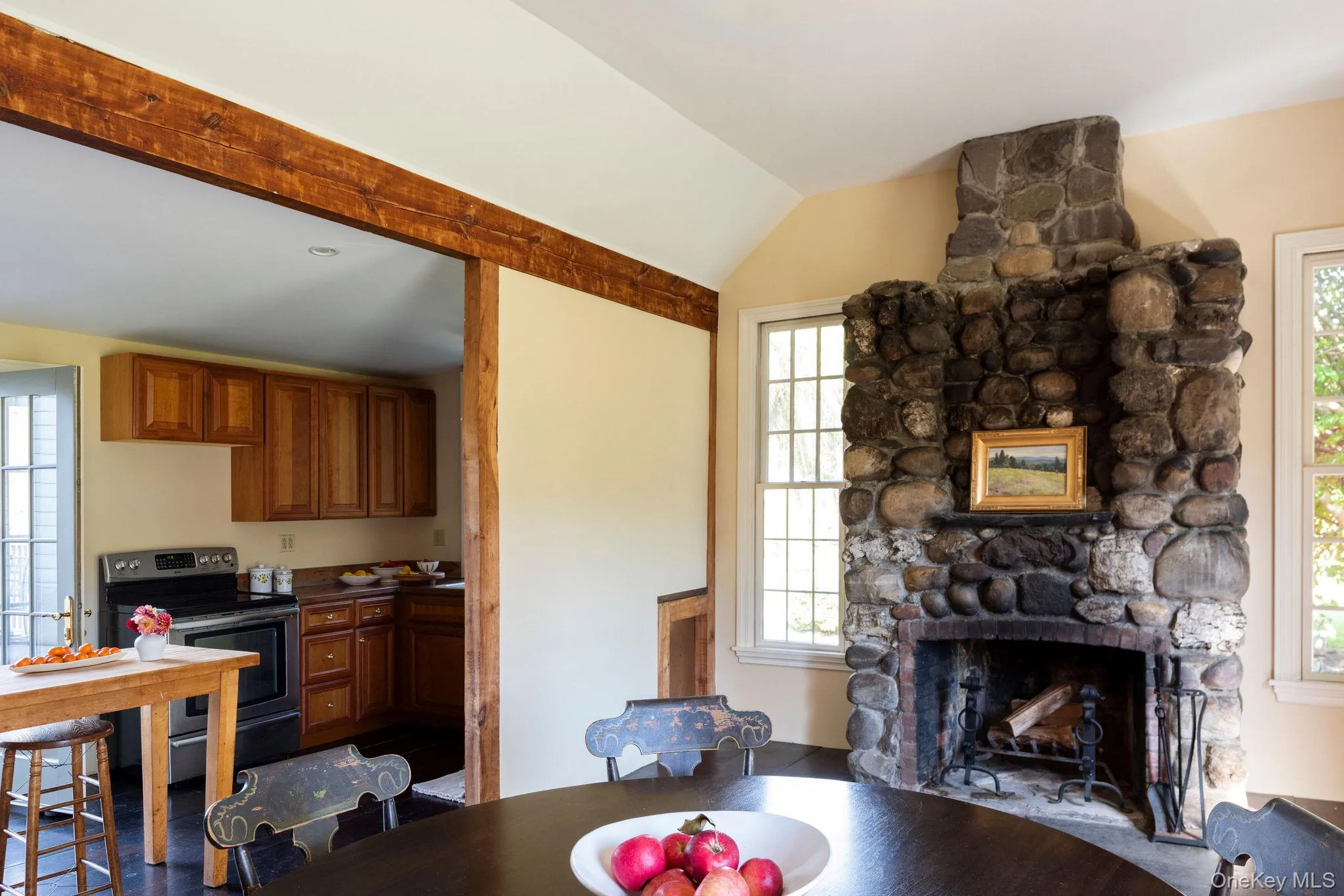 Dining room featuring a stone fireplace and lofted ceiling Dining room featuring a stone fireplace and lofted ceiling