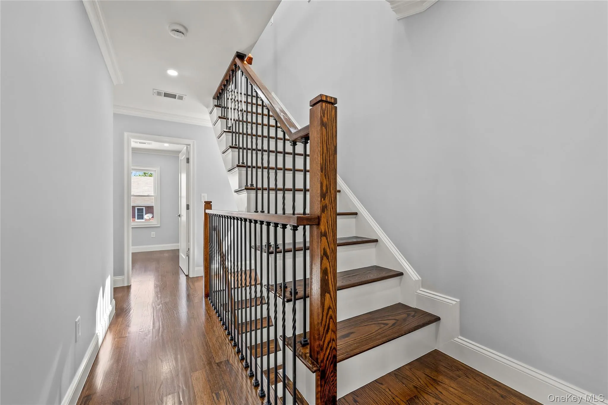 Hardwood staircase featuring dark wood treads and a wrought iron spindle railing Hardwood staircase featuring dark wood treads and a wrought iron spindle railing