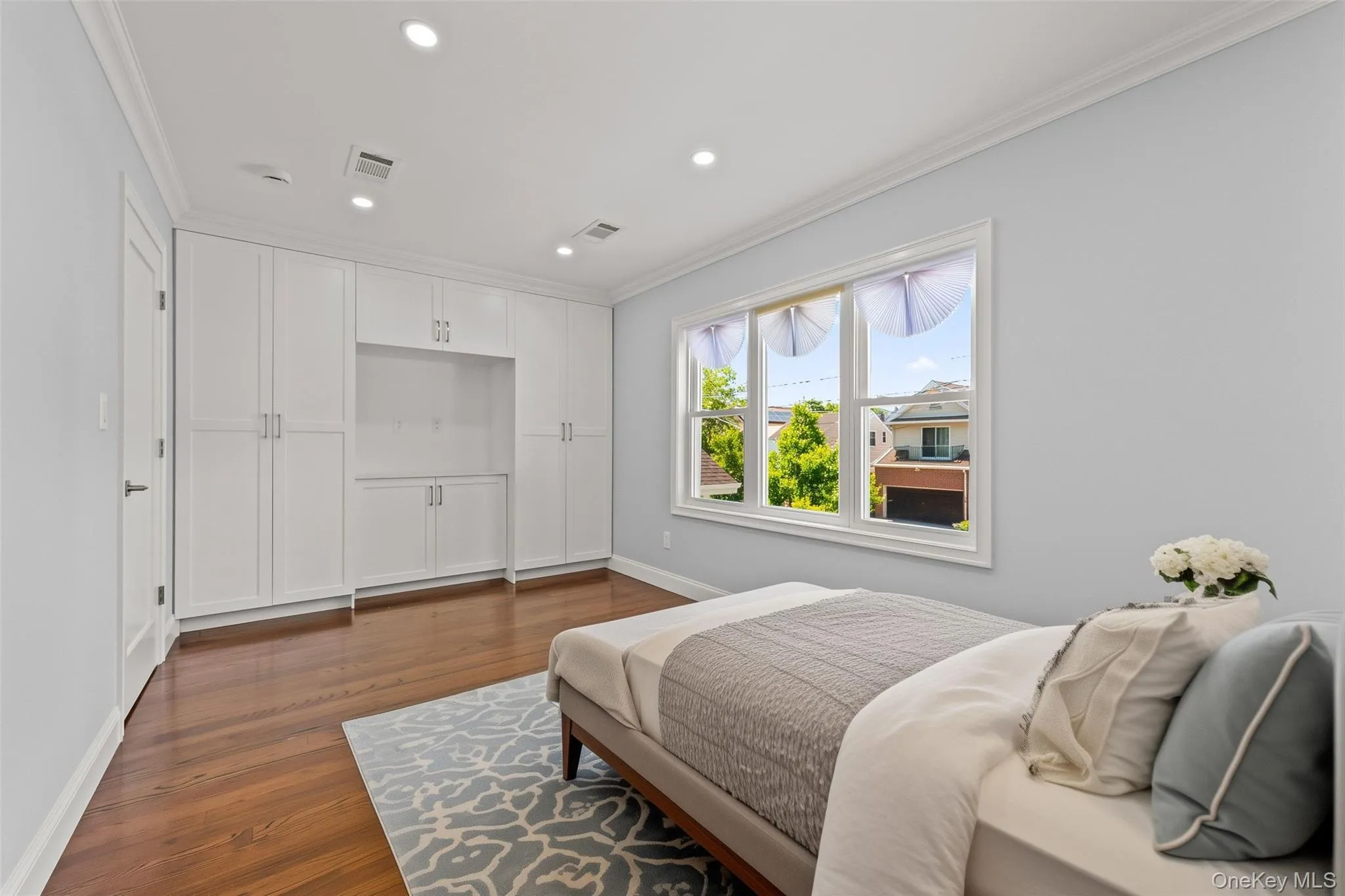 Virtually Staged -Spacious room featuring hardwood flooring, extensive built-in cabinetry, recessed lighting, and a multi-pane window Virtually Staged -Spacious room featuring hardwood flooring, extensive built-in cabinetry, recessed lighting, and a multi-pane window