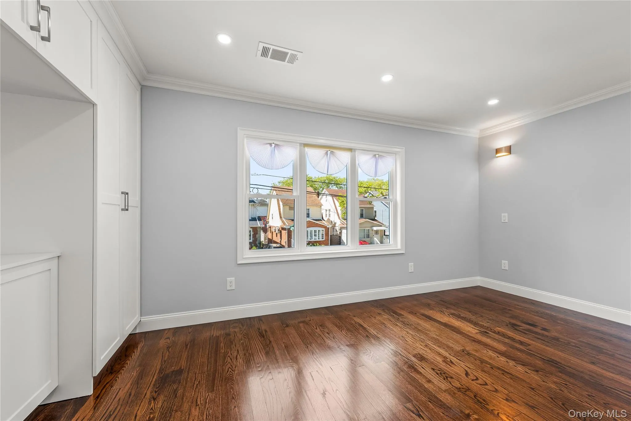 Hardwood flooring, recessed lighting, crown molding, built-in cabinetry, and a multi-pane window Hardwood flooring, recessed lighting, crown molding, built-in cabinetry, and a multi-pane window