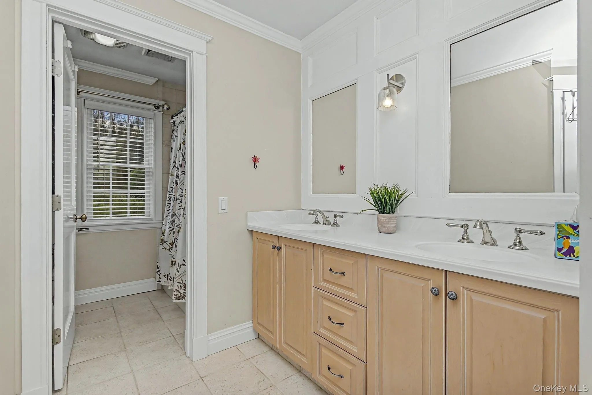 Dual vanity with integrated sinks, brushed nickel fixtures, and light-toned cabinetry Dual vanity with integrated sinks, brushed nickel fixtures, and light-toned cabinetry