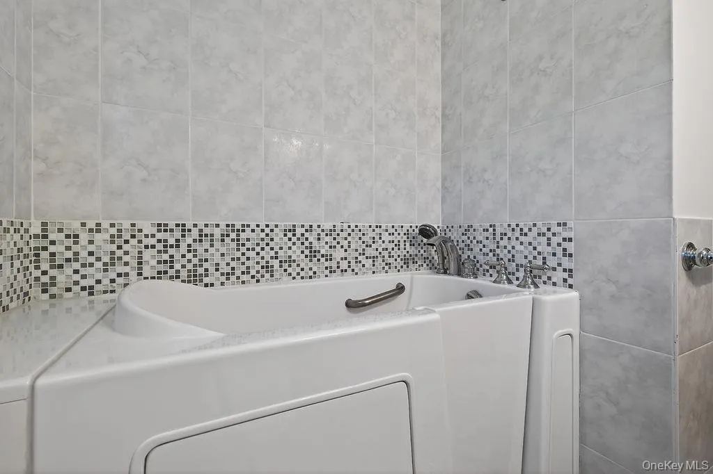 Walk-in tub with grab bar and chrome fixtures Walk-in tub with grab bar and chrome fixtures