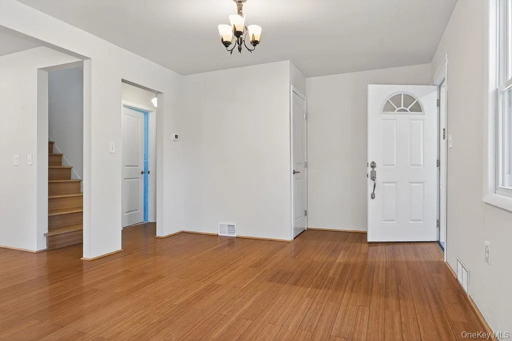 Entry area featuring wood-finish flooring, a white paneled entry door with an arched transom, and a coat closet. Entry area featuring wood-finish flooring, a white paneled entry door with an arched transom, and a coat closet.