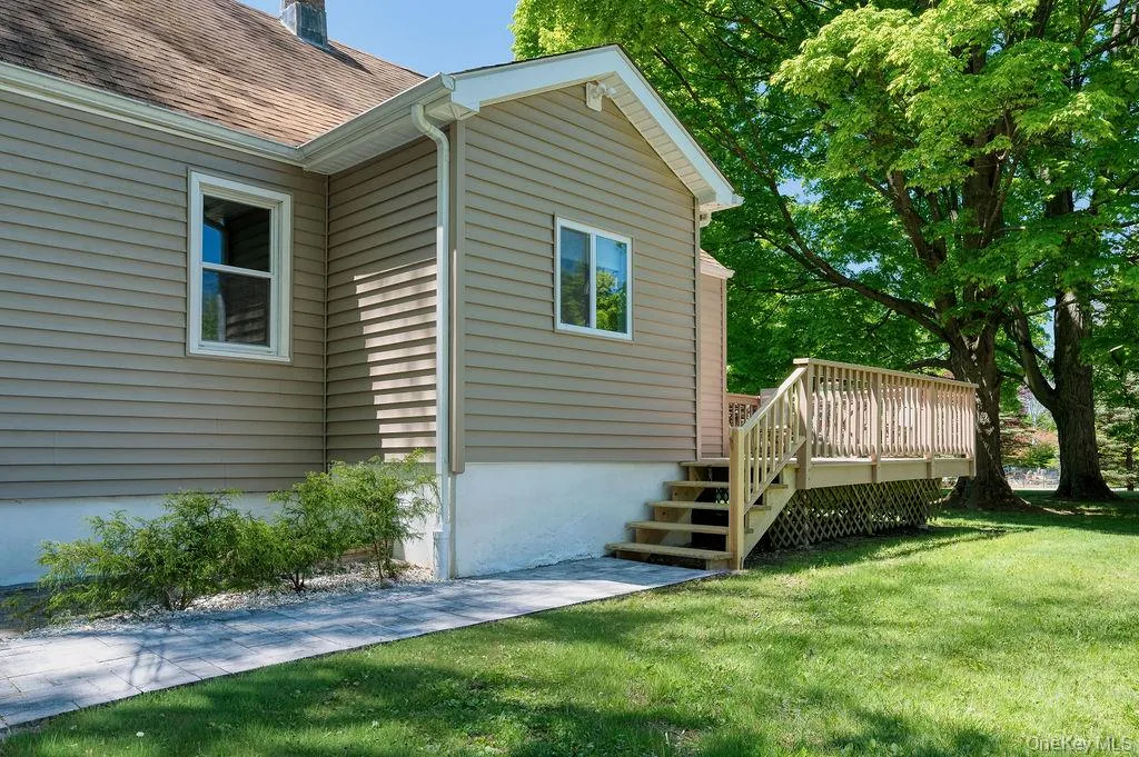 An inviting entrance with a stone walkway to a front deck and a mud room. An inviting entrance with a stone walkway to a front deck and a mud room.