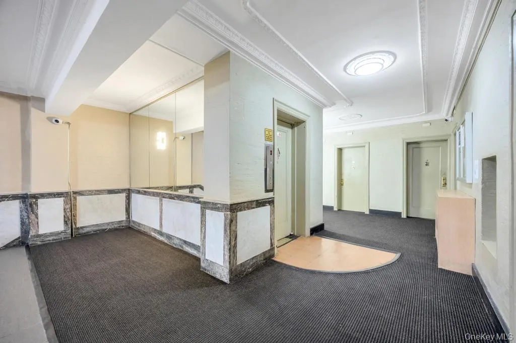 Building common area featuring patterned carpet flooring and a decorative ceiling with crown molding Building common area featuring patterned carpet flooring and a decorative ceiling with crown molding