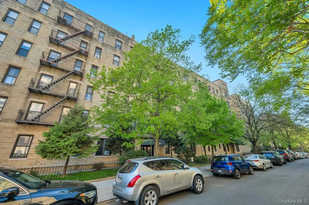 Multi-story building featuring a brick exterior and numerous windows Multi-story building featuring a brick exterior and numerous windows