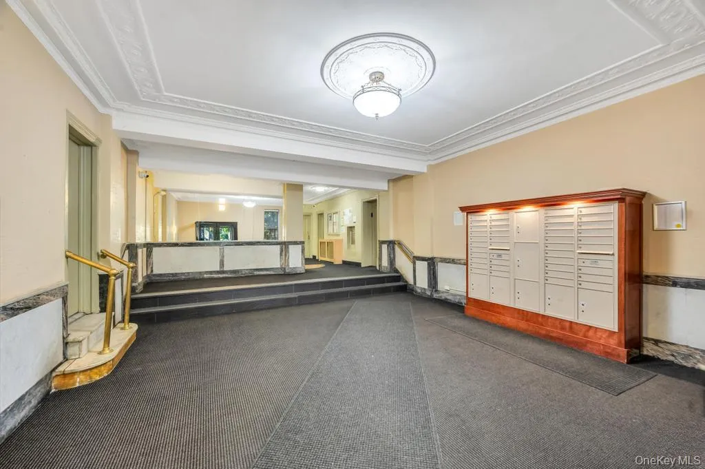 Building entryway featuring decorative ceiling molding and a built-in mailbox system with overhead illumination Building entryway featuring decorative ceiling molding and a built-in mailbox system with overhead illumination
