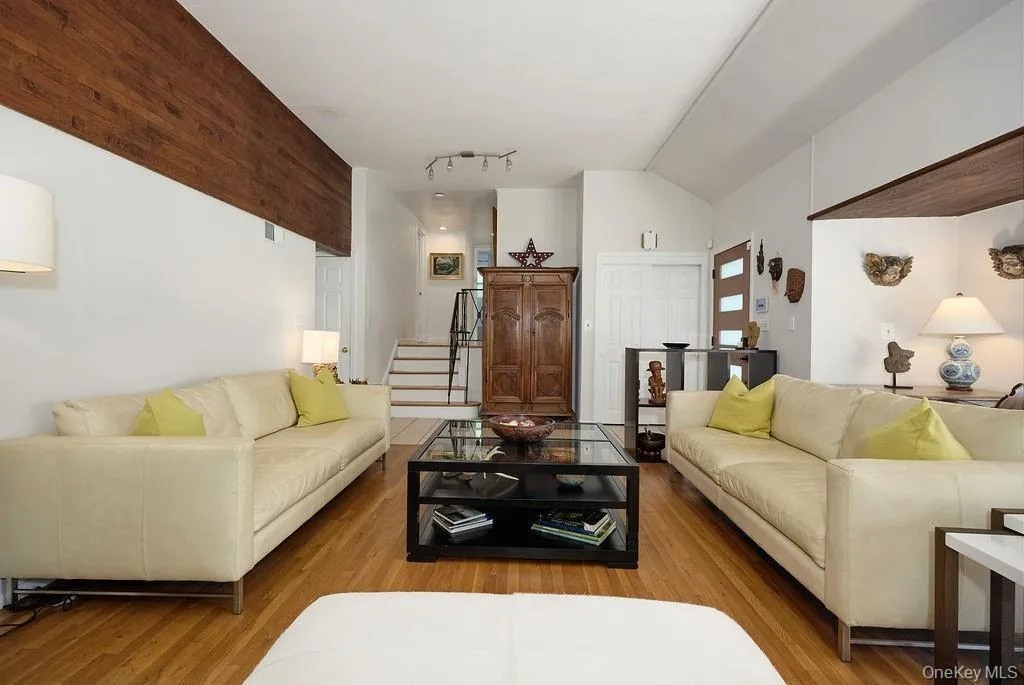 Open living area, vaulted ceiling, and a prominent wood-paneled detail Open living area, vaulted ceiling, and a prominent wood-paneled detail