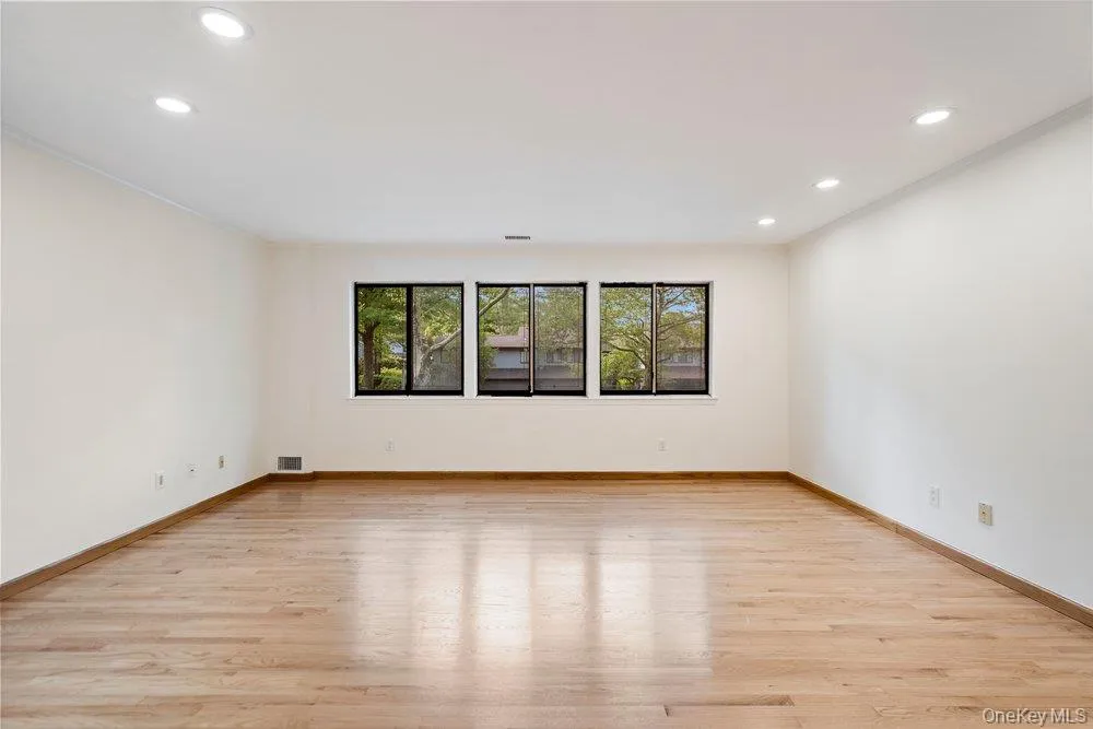 Spacious interior featuring wood-finish flooring, recessed lighting, and a neutral color palette Spacious interior featuring wood-finish flooring, recessed lighting, and a neutral color palette