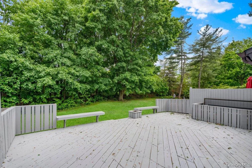 Spacious outdoor deck with painted wood flooring and slatted perimeter fencing Spacious outdoor deck with painted wood flooring and slatted perimeter fencing