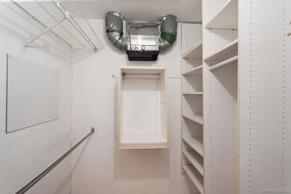 White wall-mounted wire shelving system and built-in adjustable shelving units provide ample storage White wall-mounted wire shelving system and built-in adjustable shelving units provide ample storage