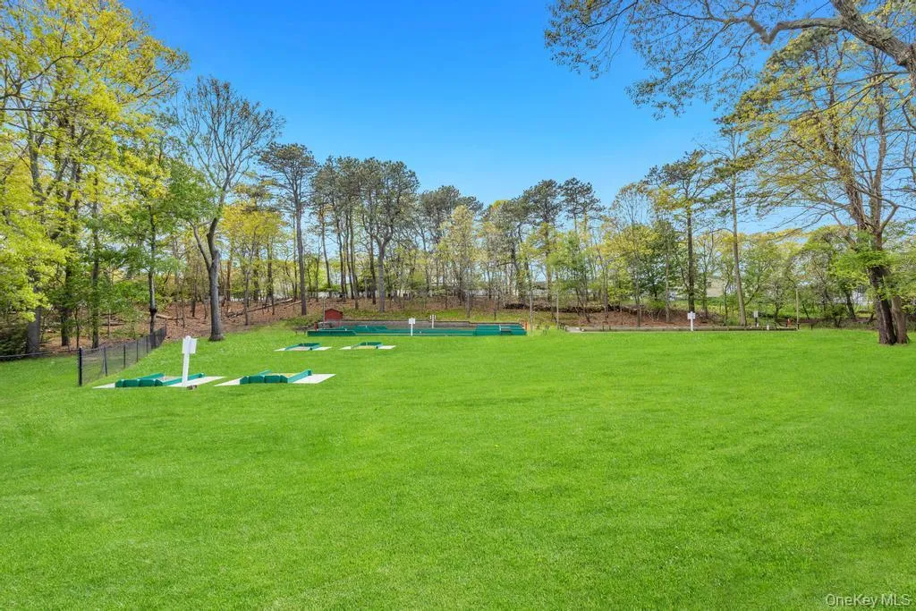 Expansive green lawn with established trees bordering the property Expansive green lawn with established trees bordering the property