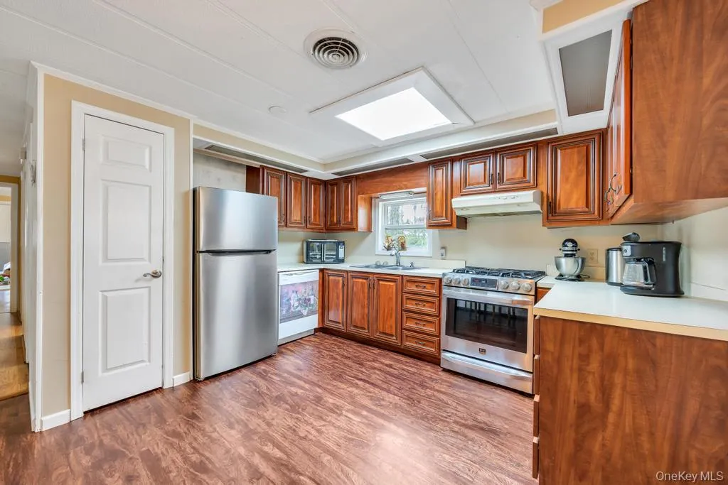 Kitchen featuring wood-finish flooring, recessed lighting, and a skylight Kitchen featuring wood-finish flooring, recessed lighting, and a skylight