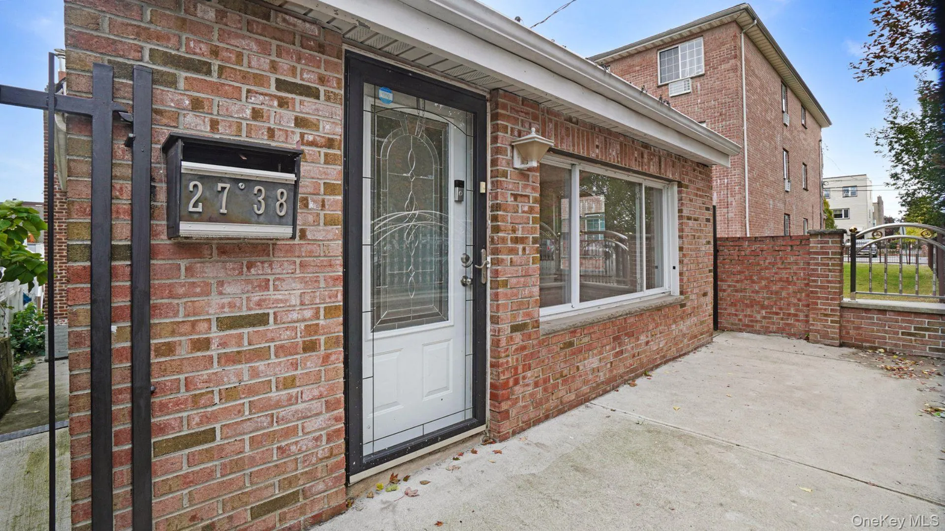 Doorway to property with brick siding, a gate, and a patio Doorway to property with brick siding, a gate, and a patio