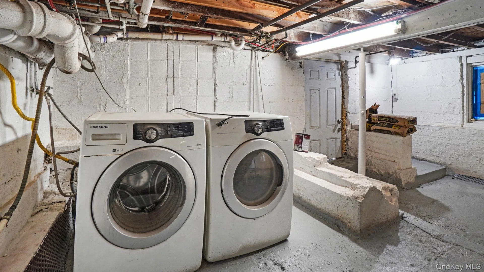 Washroom featuring concrete flooring and washer and dryer Washroom featuring concrete flooring and washer and dryer