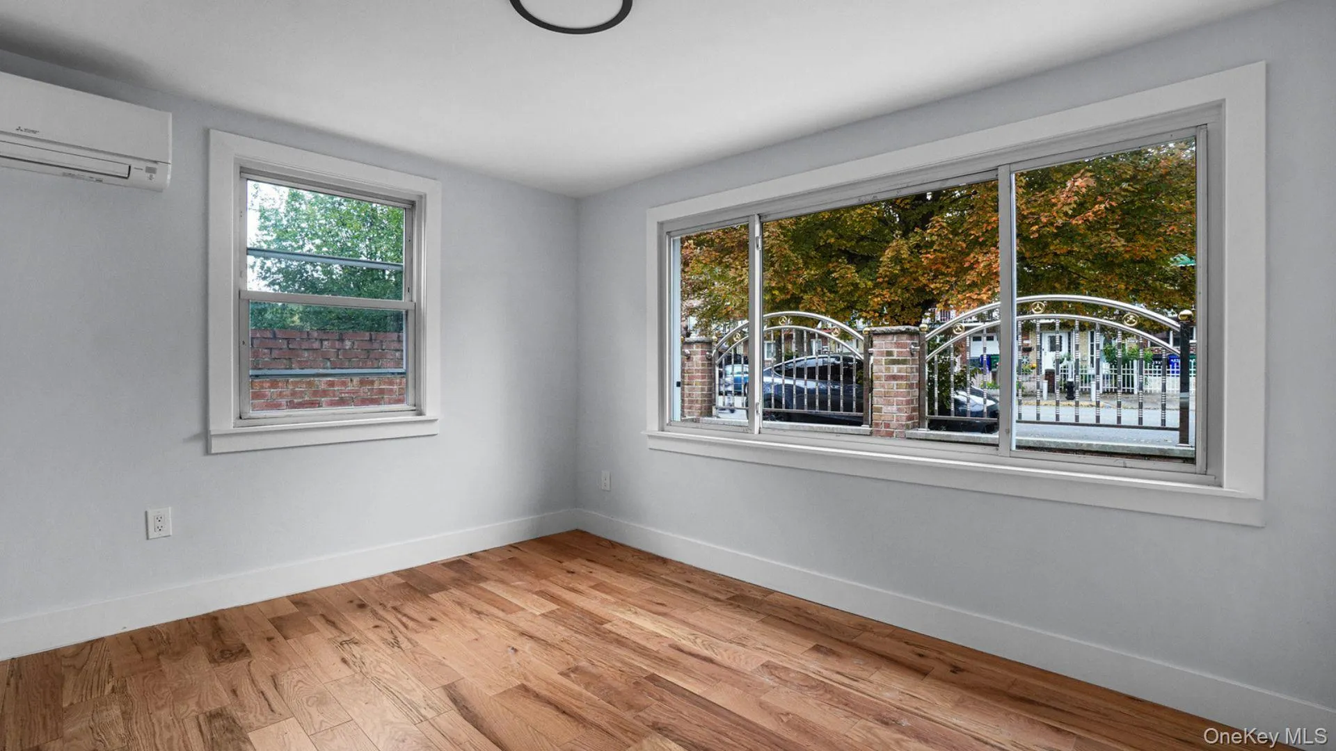 Empty room with light wood-style floors and a wall mounted air conditioner Empty room with light wood-style floors and a wall mounted air conditioner