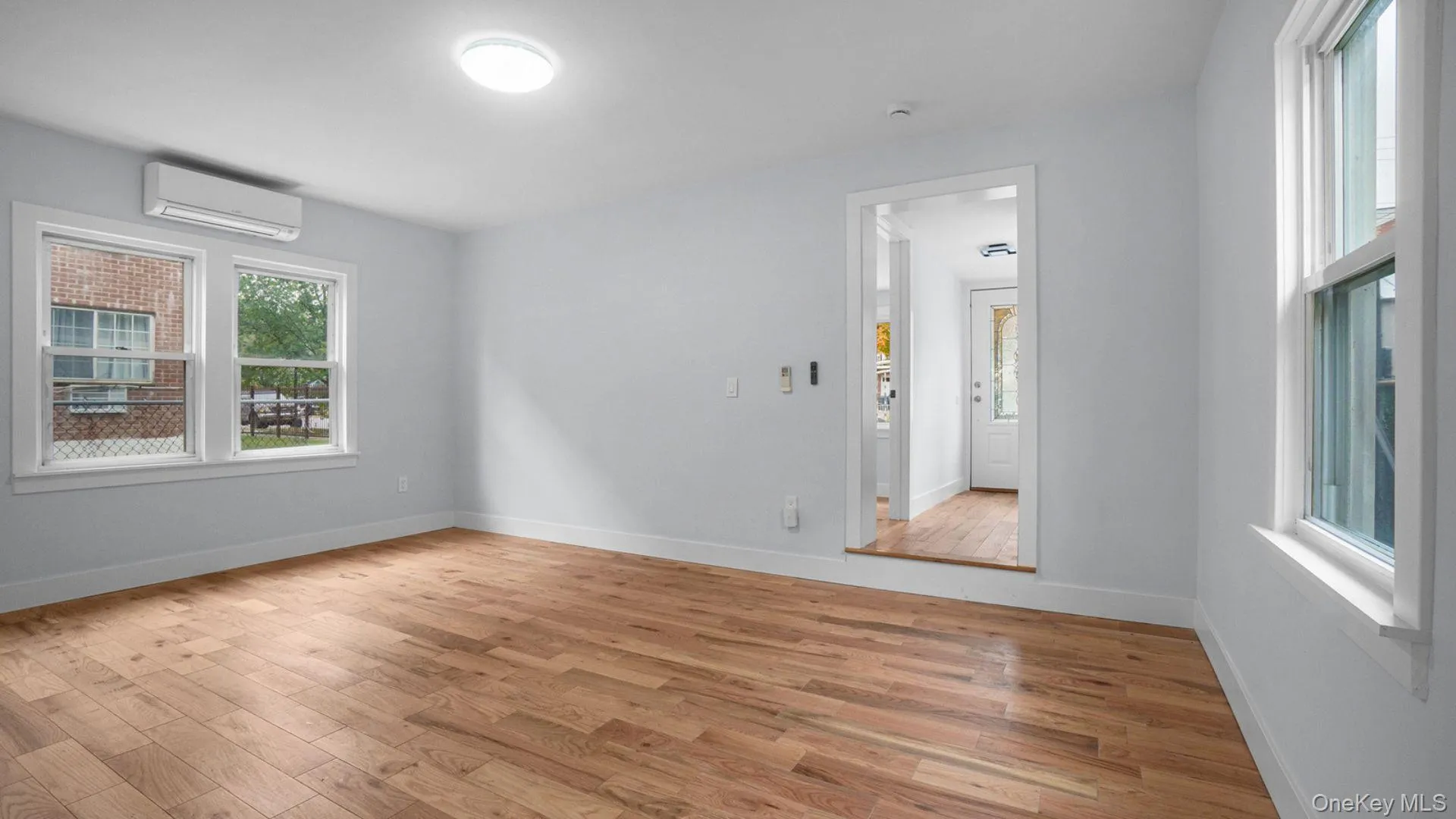 Spare room featuring light wood-style floors and a wall mounted air conditioner Spare room featuring light wood-style floors and a wall mounted air conditioner
