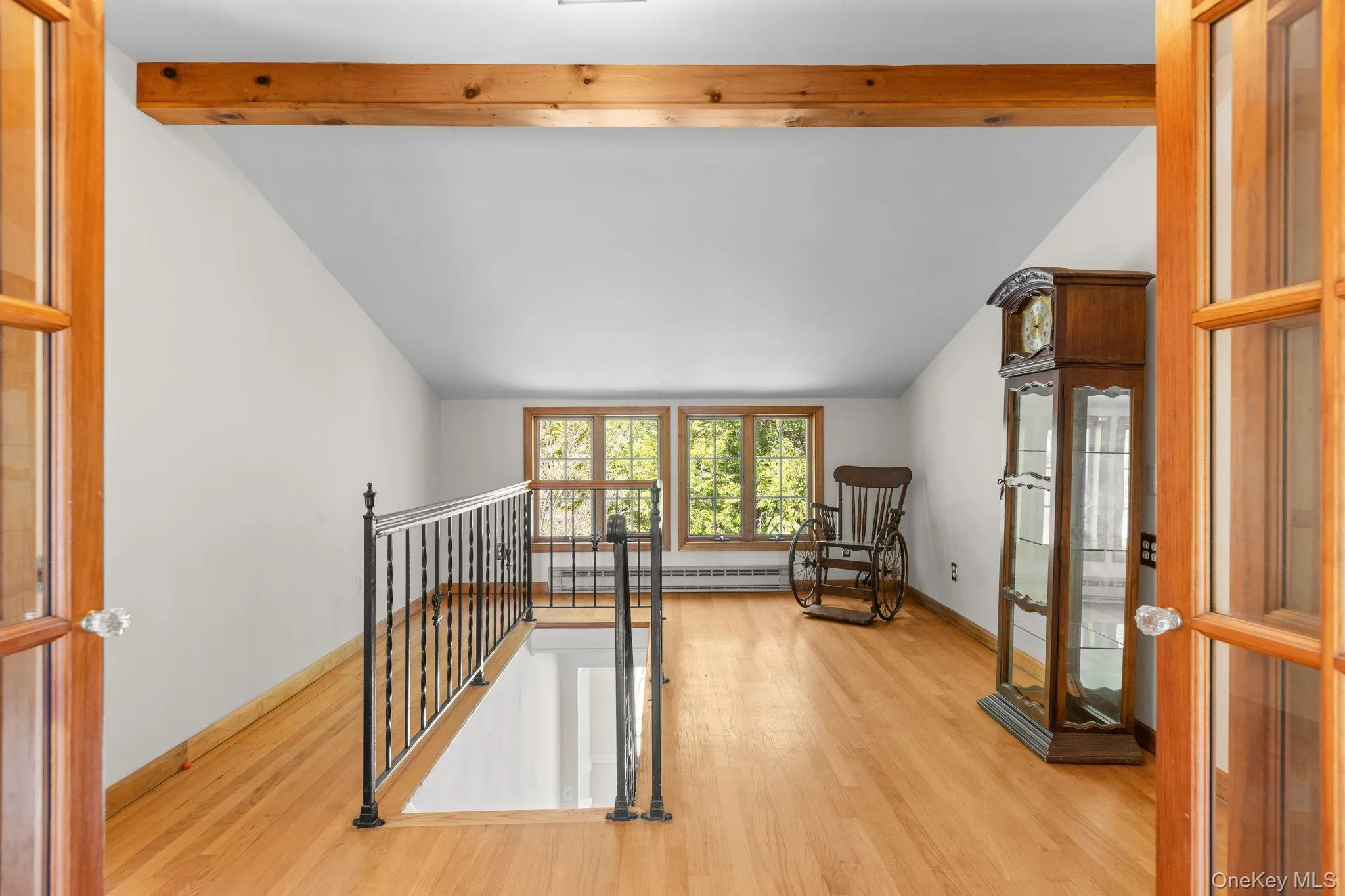 Upstairs an open area presents with hardwood floor and beam accent ceiling Upstairs an open area presents with hardwood floor and beam accent ceiling