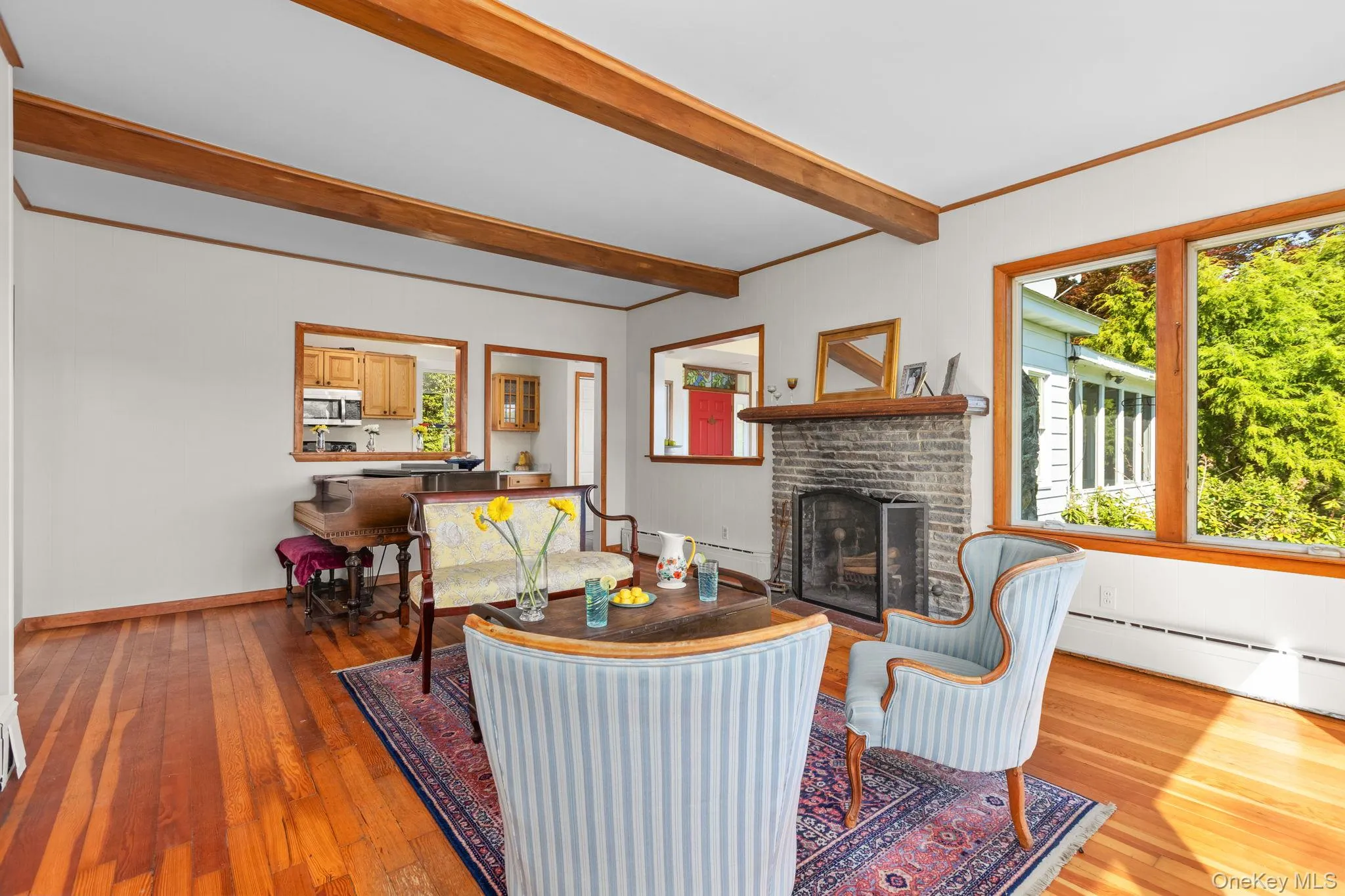 The sundrenched room is enhanced by hardwood floor, large windows, wood burning fireplace and beamed ceiling The sundrenched room is enhanced by hardwood floor, large windows, wood burning fireplace and beamed ceiling