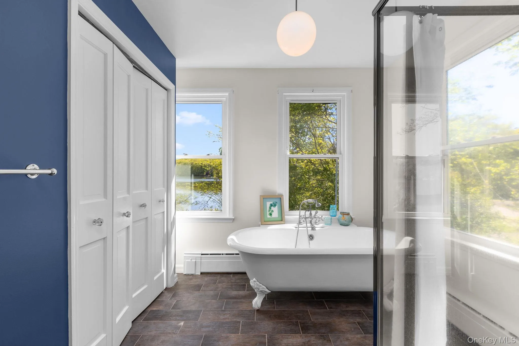 The main level bath is complete with lake views, pedestal sink, glass enclosed shower and soaking tub The main level bath is complete with lake views, pedestal sink, glass enclosed shower and soaking tub