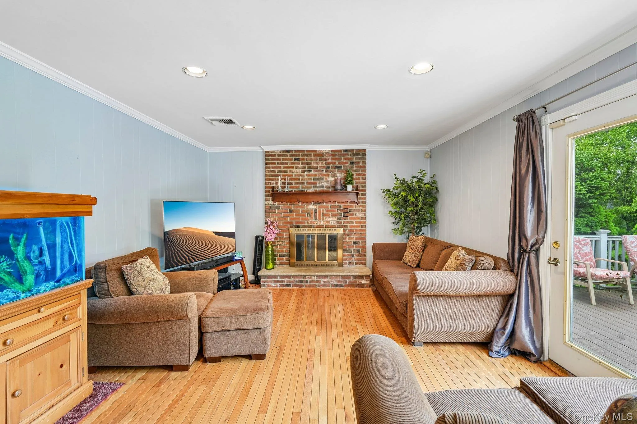 Warm and inviting family room featuring hardwood floors, a brick fireplace, and sliding doors providing access to the backyard. Warm and inviting family room featuring hardwood floors, a brick fireplace, and sliding doors providing access to the backyard.