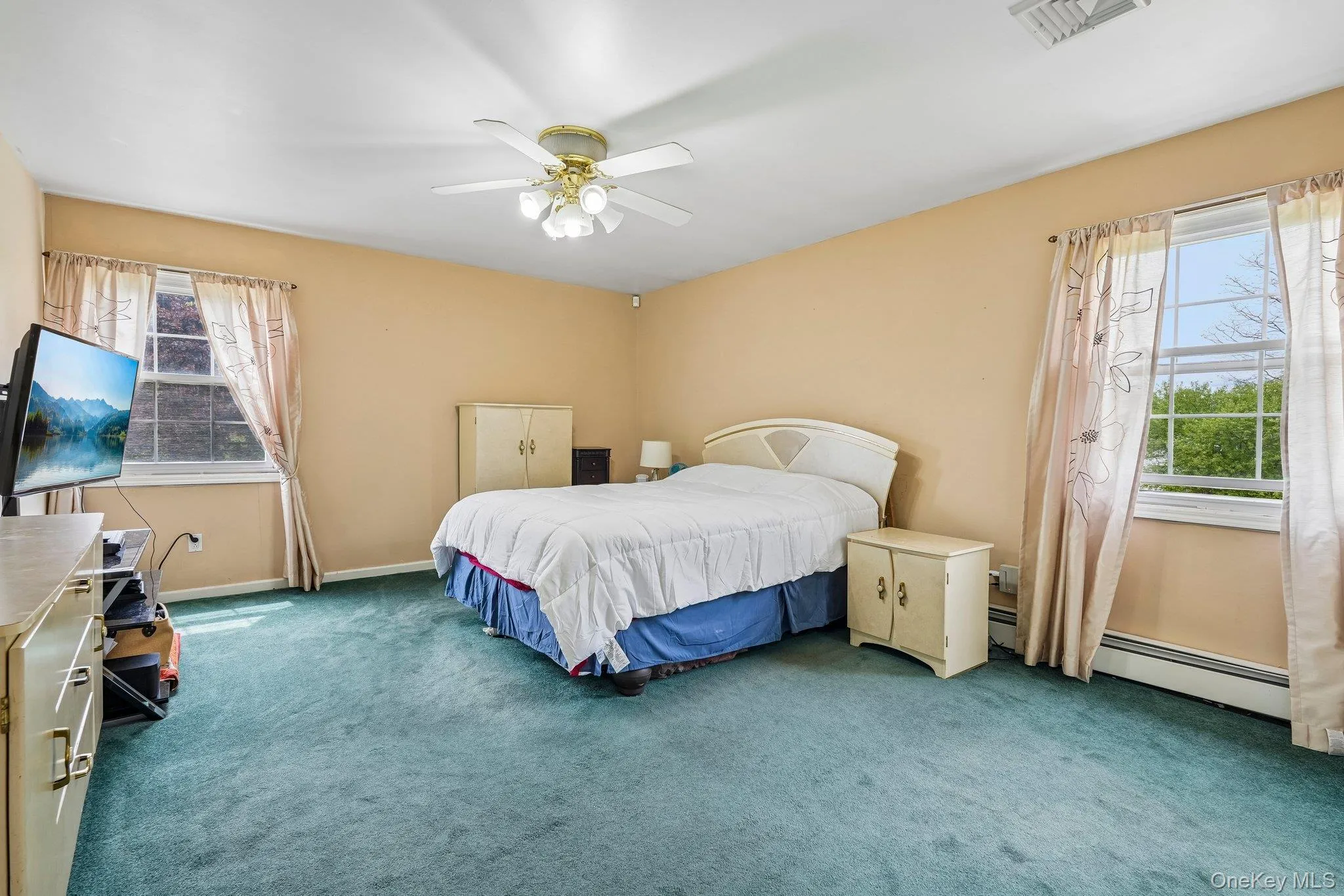 Spacious primary bedroom featuring large windows, a comfortable layout, and abundant natural light. Spacious primary bedroom featuring large windows, a comfortable layout, and abundant natural light.