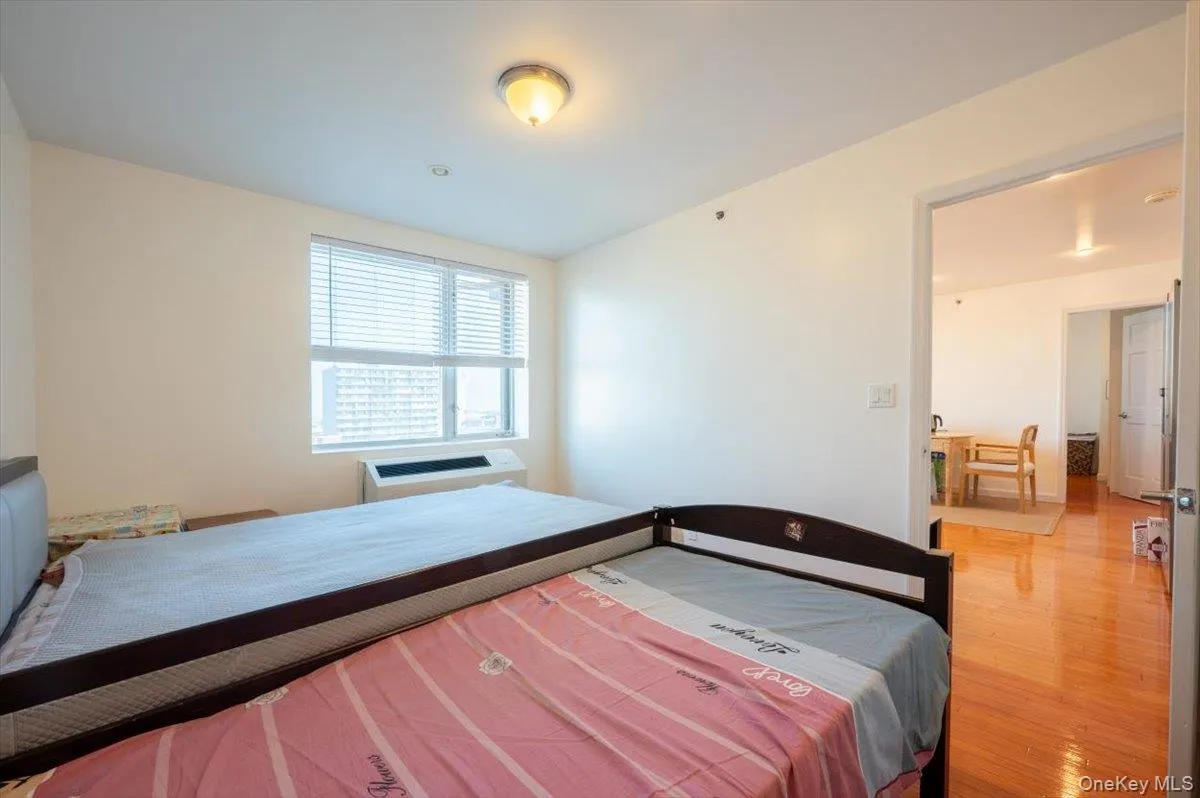 Bedroom featuring light wood-style flooring and a wall mounted AC Bedroom featuring light wood-style flooring and a wall mounted AC