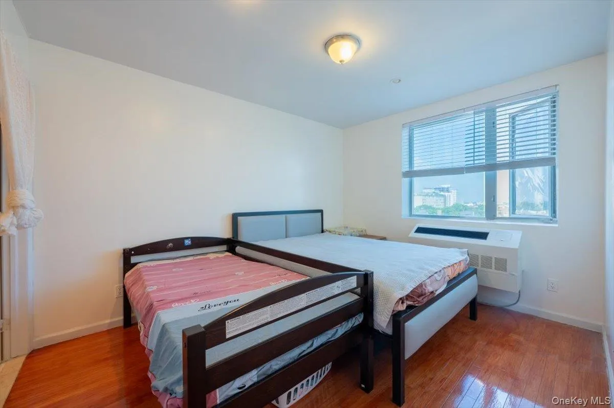 Bedroom with radiator and wood finished floors Bedroom with radiator and wood finished floors
